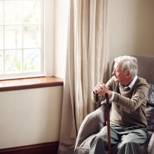 an elder man sitting by a window