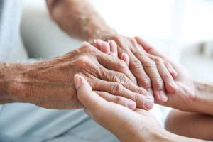 Young woman holding senior man hands, closeup